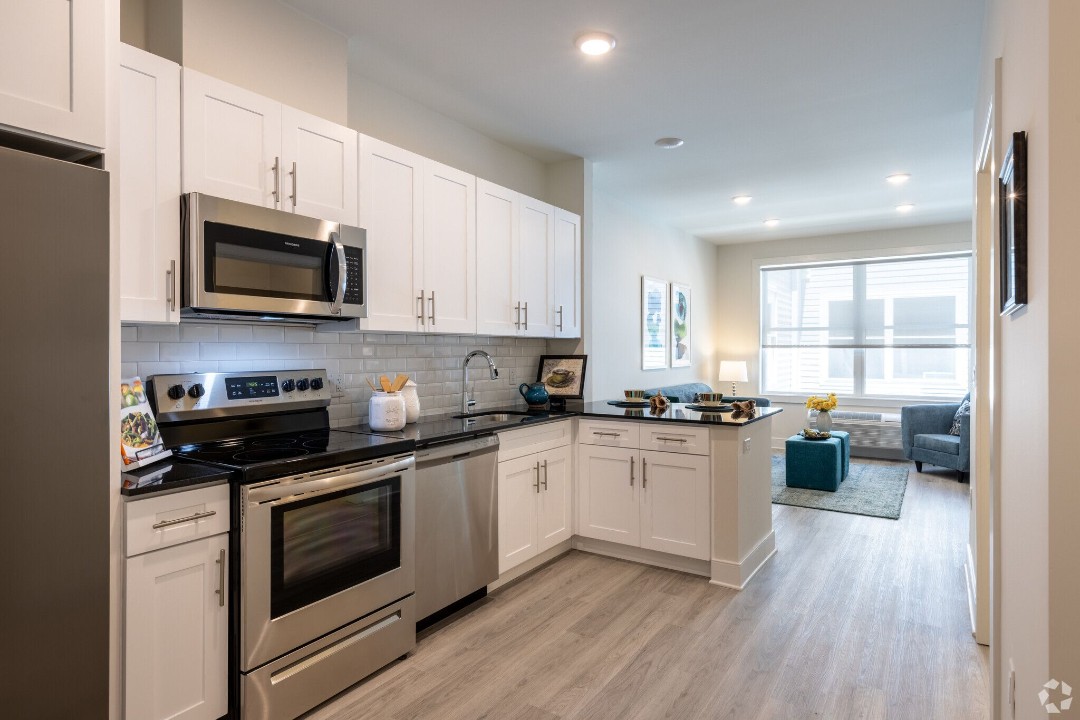 Modern kitchen with white cabinets, stainless steel appliances, and granite countertops at 127 The View