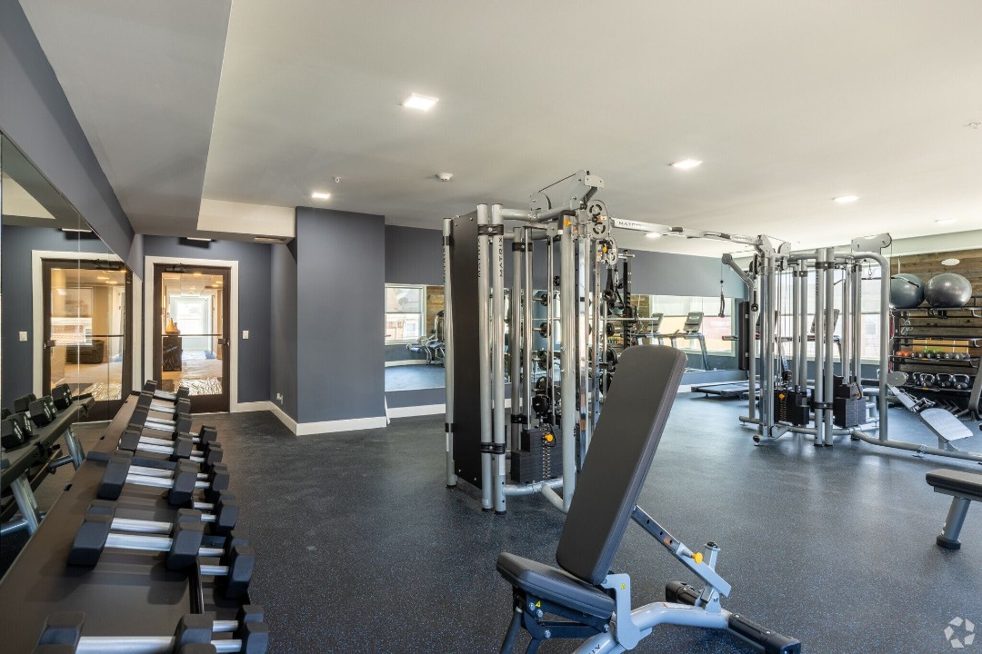 Fitness center with free weights, cable machines, and cardio equipment