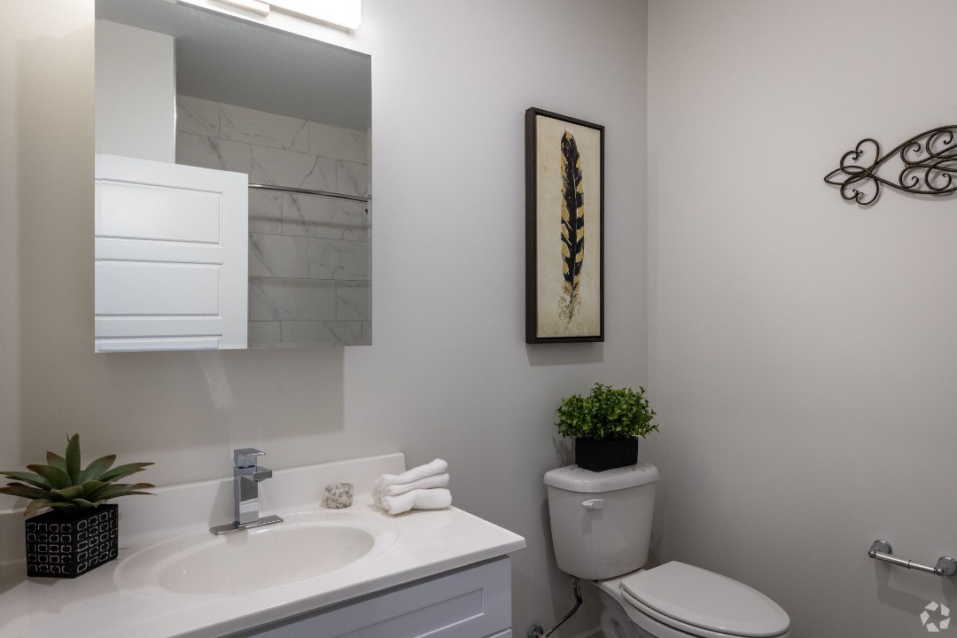 Modern bathroom with vanity, medicine cabinet, and marble-style tile
