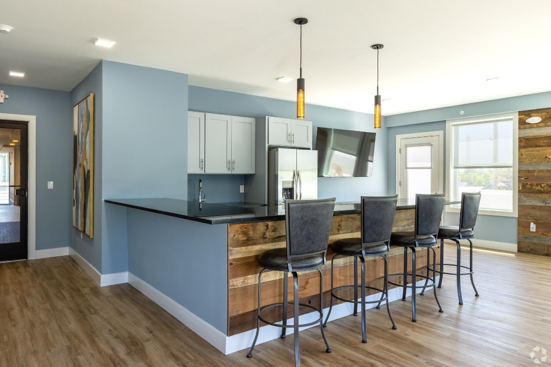 Community lounge with kitchen bar and reclaimed wood accents